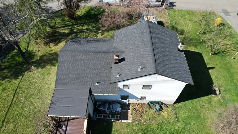 Completed shingle roof replacement with new pipe flashings and chimney flashing