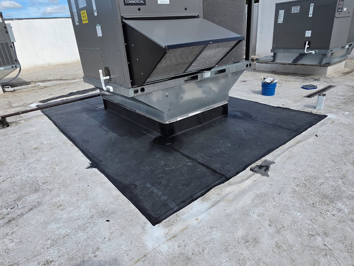 New EPDM membrane section installed around the curb of a rooftop HVAC unit on a commercial flat roof