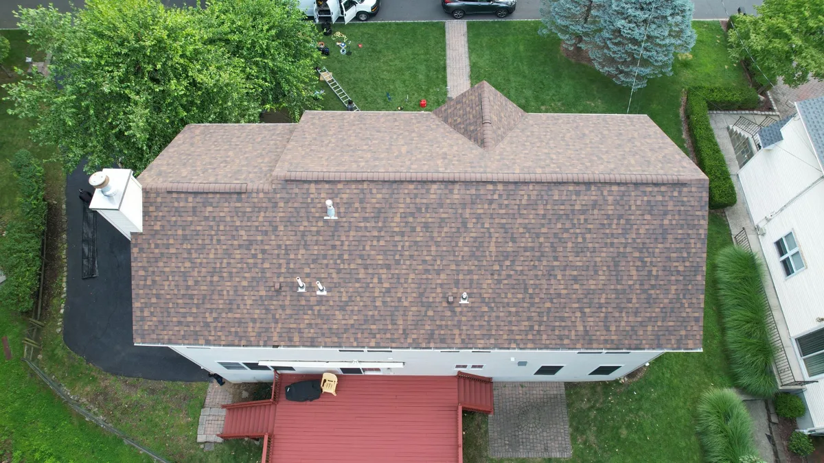 Aerial view of a finished brown-blend architectural shingle roof on a split-level home in Montvale, NJ