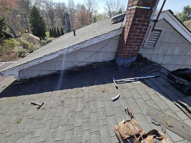 During the repair: old shingles stripped around the chimney and along the gable wall