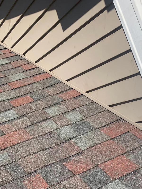Finished repair with new shingles along the dormer wall