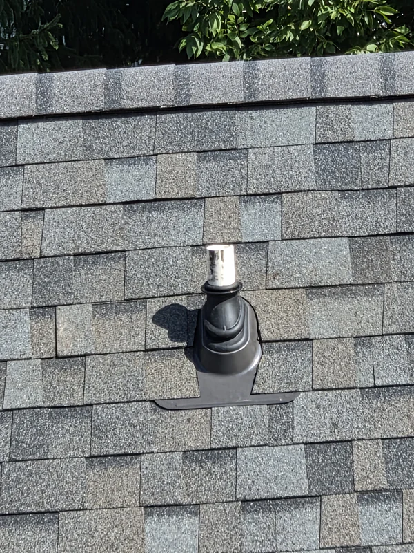 New pipe boot flashed into a gray architectural shingle roof