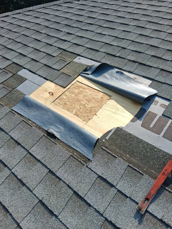 Storm damage repair in West Orange: a new section of roof decking set in where the damaged wood was cut out, with the underlayment folded back