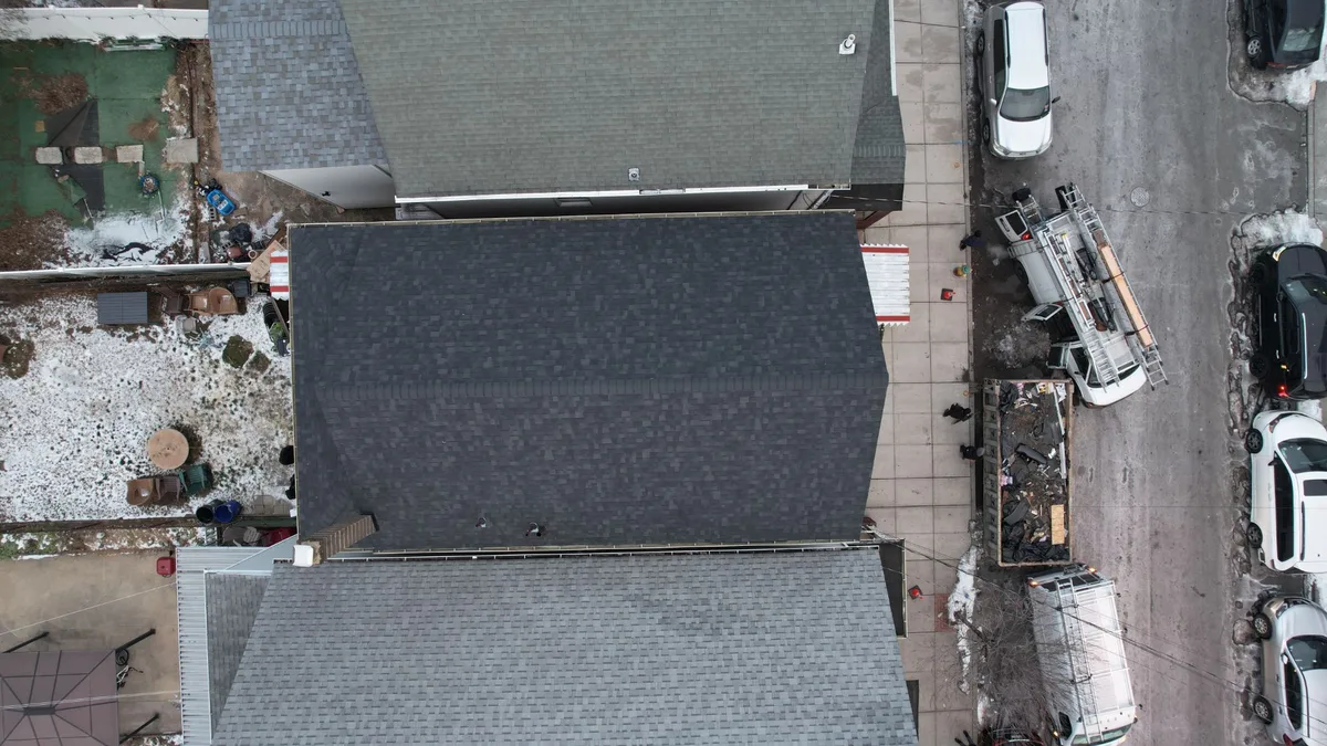 Aerial view of a new charcoal architectural shingle roof on a rowhouse in winter