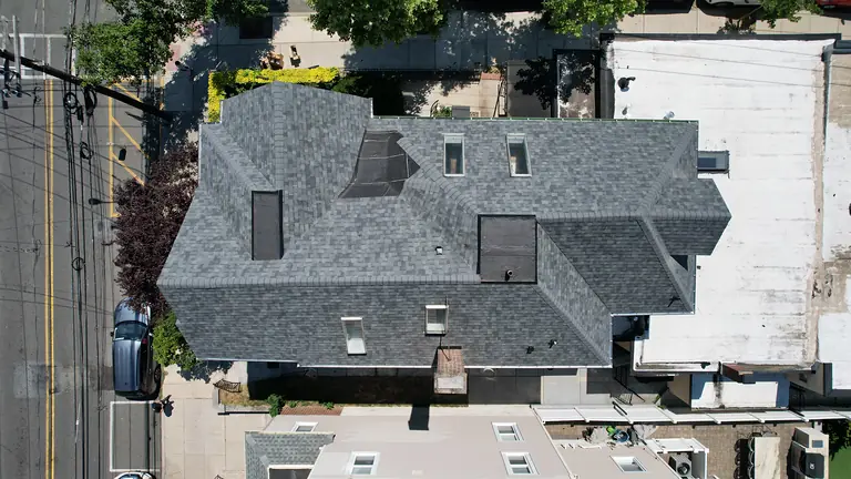 New shingle roof with four skylights and low-slope sections on a multi-family building