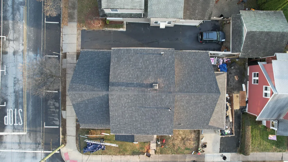 Aerial view of the same two-family home finished with gray architectural shingles